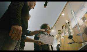 Ciak della scena 37 Alessandro Gallo accompagna Robin Le Mesurier nella scelta della chitarra